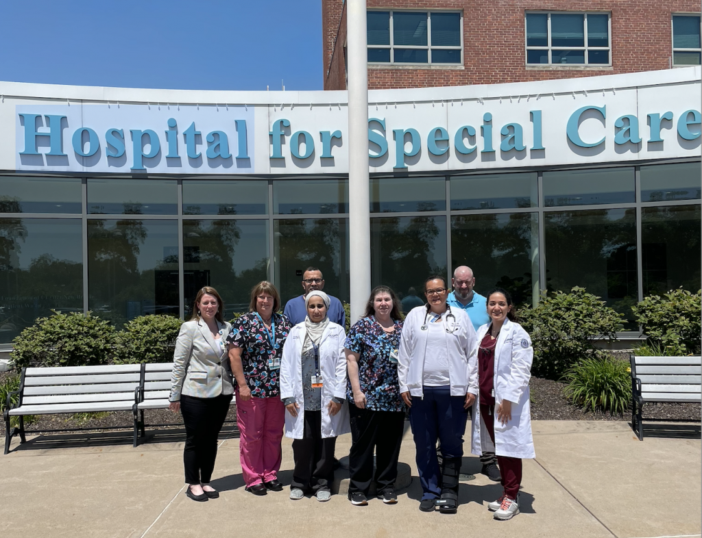 A group of dentists and hospital leaders posing outside of the building
